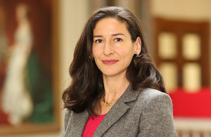 Head shot of Alumni Alexandra Mckenzie wearing a suit and smiling at the camera