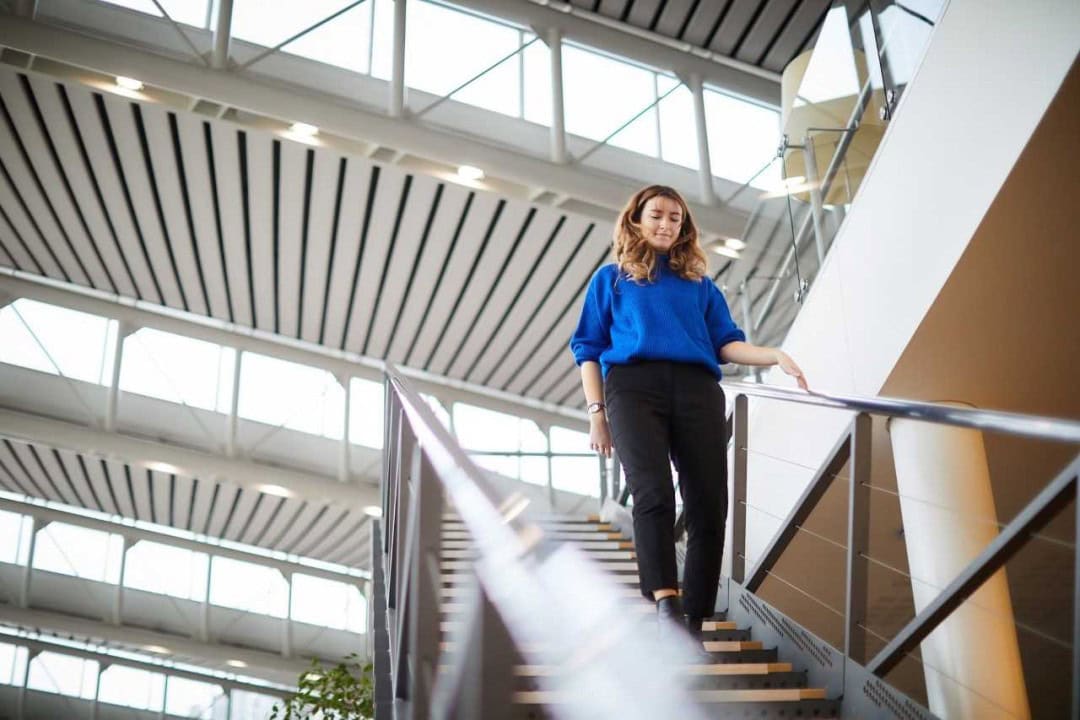 Alumni, Tania Curtis walking down the stairs at the BP Office