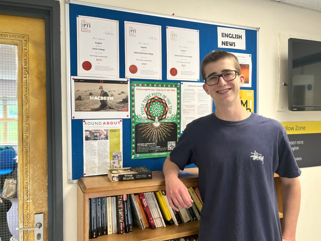 Louis standing by the bookcase in the humanities corridor
