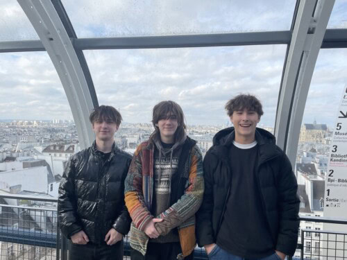 3 male students in a rooftop space overlooking Paris