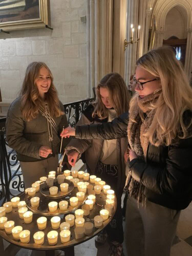 female students lighting candles in Notre Dame