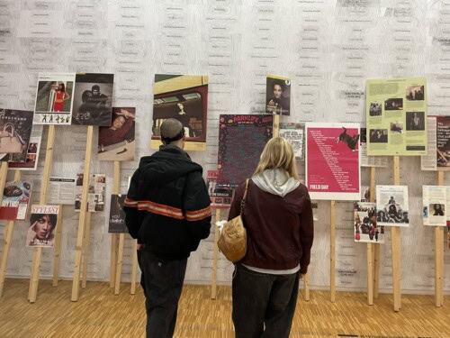 two students looking at artwork in a gallery