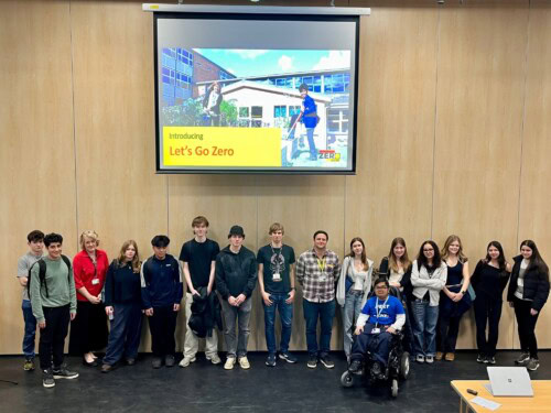 Students standing at the front of the college theatre after a presentation