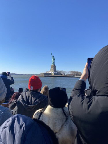 students taking a photo of the Statue Of Liberty