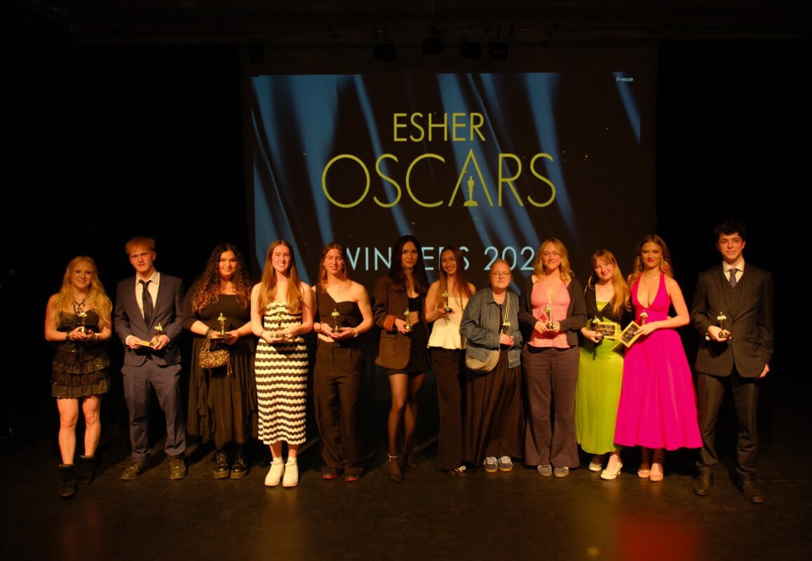 Students standing on a stage with Oscar statues