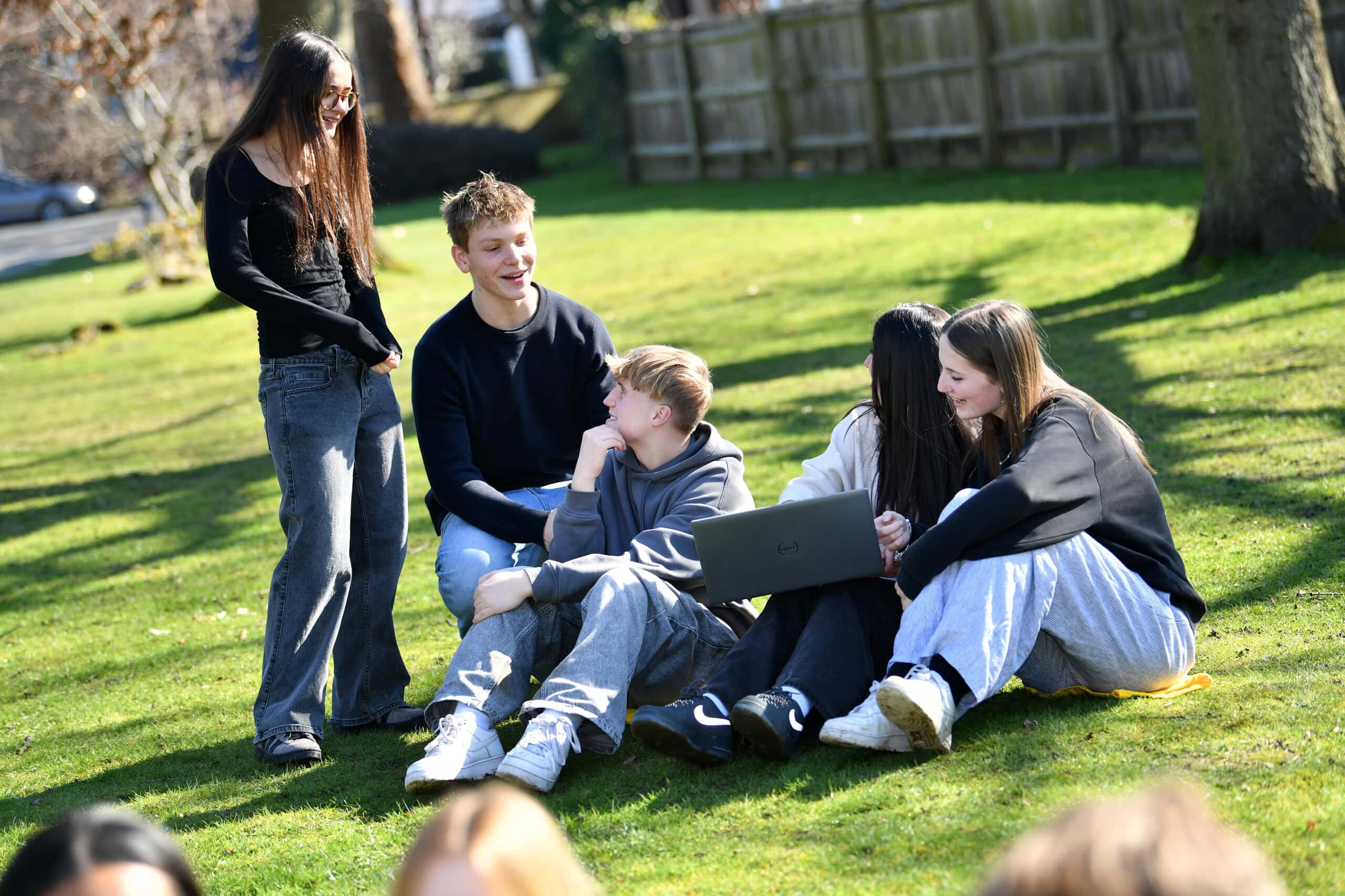 a group of students sitting the sun chatting