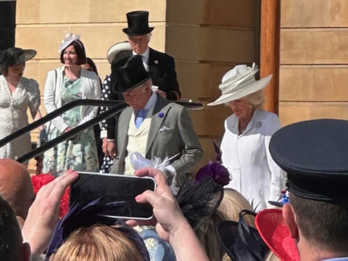 King Charles And Queen Camilla walking down steps